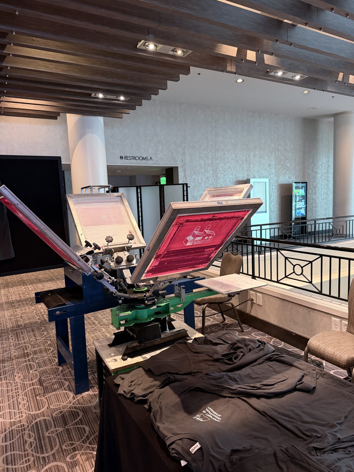 Guests watching a printer pull a squeegee at a Miami event